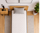 Bovenaanzicht van de Flora matras 90x200 cm op een houten lattenbodem in een lichte slaapkamer