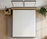 Bovenaanzicht van de Flora matras 140x200 cm op een houten lattenbodem in een lichte slaapkamer