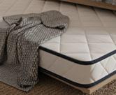 Detail van de rand van de Essential Oli matras – tijk van 100% ademend en zacht polyester met marineblauwe bies